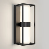 A modern wall sconce light with a rectangular black metal frame and a cylindrical white frosted glass shade, mounted on a light-colored wall.