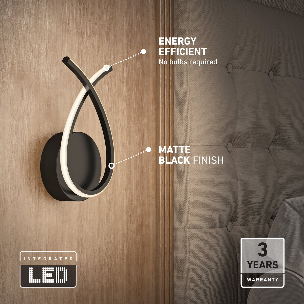 Modern wall-mounted light with a matte black finish and curved integrated LED design is installed beside a upholstered bed. Text highlights its energy efficiency and 3-year warranty; no bulbs are required.
