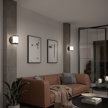 Modern living room with brown sofa, abstract art, and patio featuring Artika Landon LED Outdoor Wall Light 2-Pack accents.