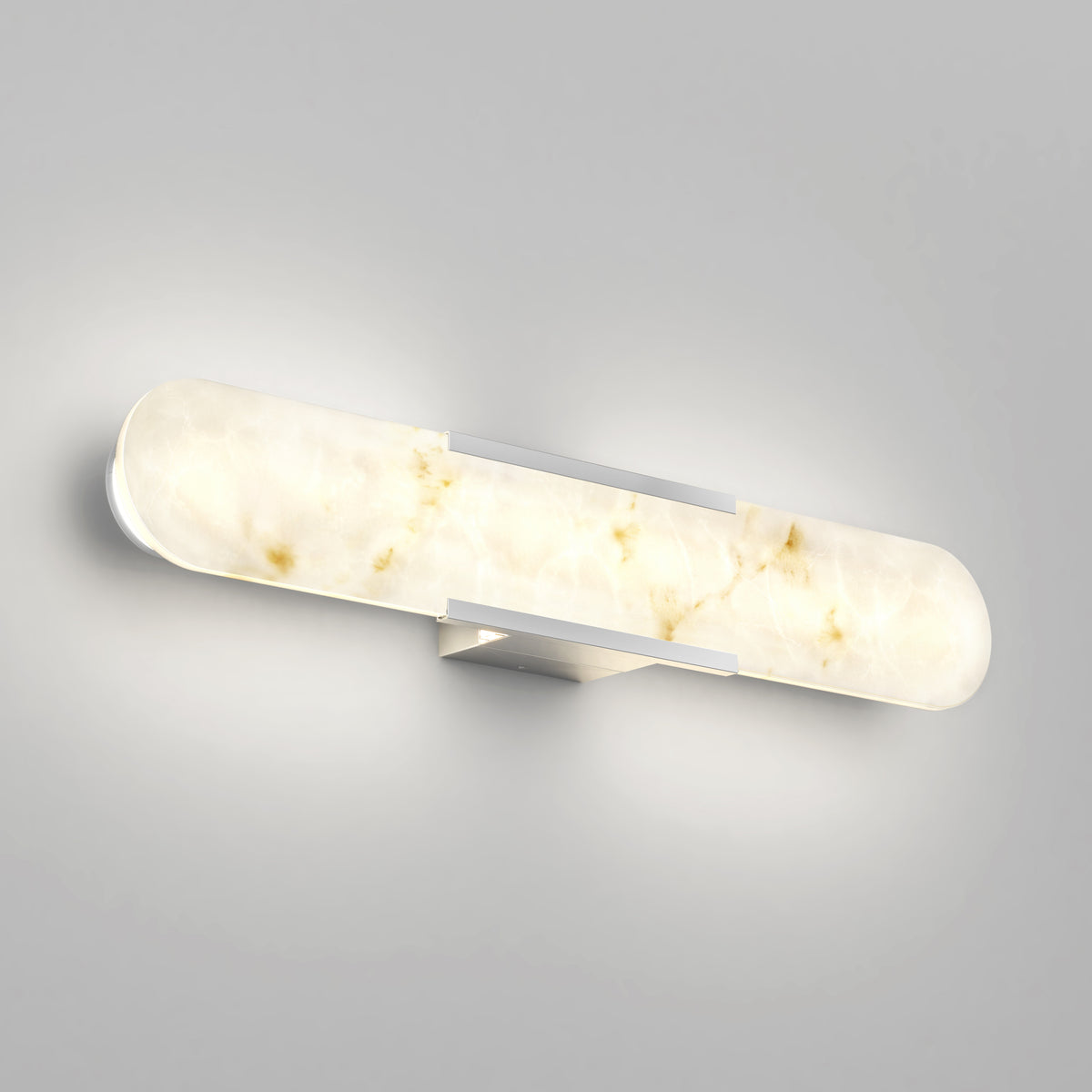 A modern wall-mounted light fixture with a rounded, elongated design and a marbled white glass cover, emitting a soft, warm glow against a light gray wall.