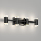 A modern black wall sconce light fixture with four cylindrical lights, each with frosted ends, mounted on a rectangular backplate against a plain gray wall.