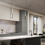 Modern kitchen with gray and white cabinets, a marble backsplash, a black faucet, and a large island. Two unique oval pendant lights hang above the island, and large windows allow natural light into the room.