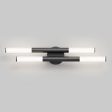 Modern wall-mounted light fixture with two horizontal, cylindrical LED bars intersecting at a central round black base, set against a plain gray background. The bars are black and white, emitting a soft light.