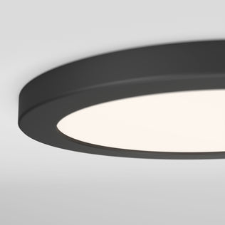 Close-up of the Artika Europa Disk 9 in. LED modern flush mount light 3 CCT, a round black ceiling fixture with a white illuminated surface, shown against a plain white ceiling.