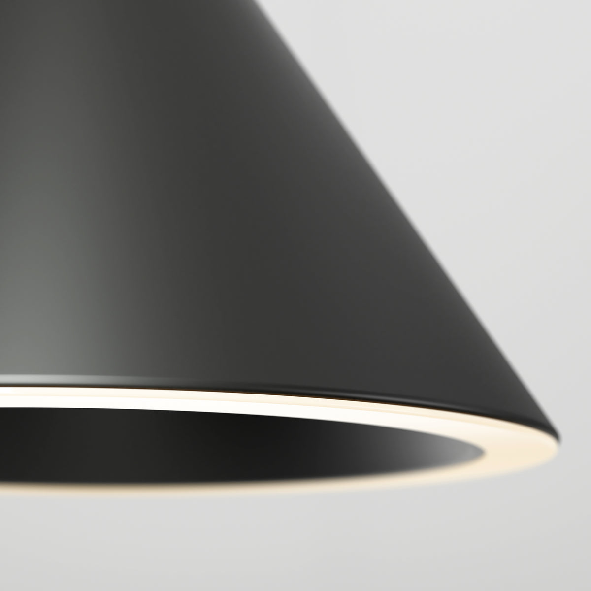 Close-up of Artika’s Denali modern LED pendant light 3 CCT—a sleek, black cone-shaped design with a glowing white rim—shown against a plain, light gray background.