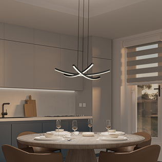 A modern kitchen with beige cabinets and a round dining table set with dishes and glasses features the Artika Orly modern LED pendant light 5 CCT as a sculptural centerpiece above. Sunlight streams in through striped blinds.