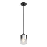 A modern pendant light with a black ceiling mount, a long black cord, and a cylindrical clear glass shade, displaying a glowing bulb inside.