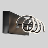 A modern wall-mounted light fixture with a black rectangular base and three overlapping, illuminated circular rings extending outward, set against a plain light gray background.