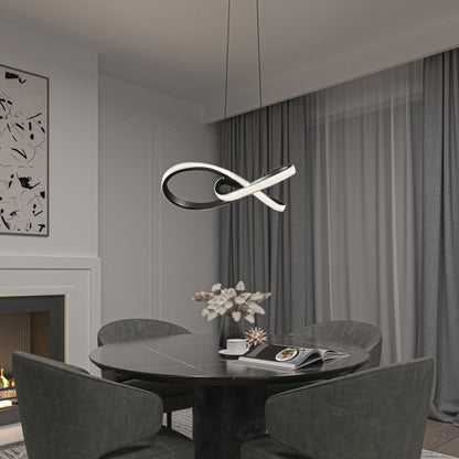 A modern dining area features a round black table, four dark green chairs, a stylish centerpiece, and the Artika Morgan LED contemporary pendant light. Gray curtains cover large windows, with abstract art above a white fireplace.