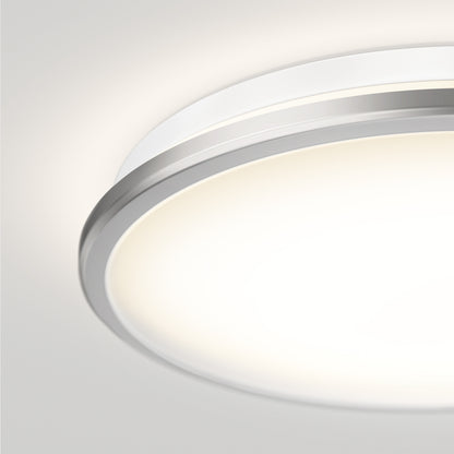Close-up of the Artika Vera 13 in. LED modern flush mount light, featuring a sleek chrome finish and minimalist design, emitting a soft white glow on a smooth, light-colored ceiling.