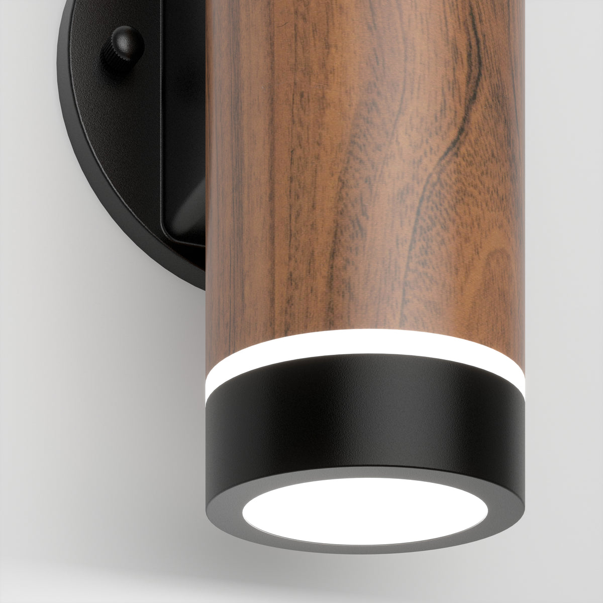 The Artika C7 indoor-outdoor LED wall light 3 CCT features a cylindrical wood-textured body, black accents, and a glowing white light from the bottom, shown mounted on a light-colored wall.