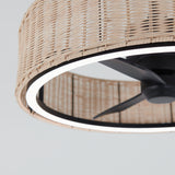 A close-up view of a ceiling fan with black blades, surrounded by a circular LED light and a woven rattan shade, set against a light gray background.