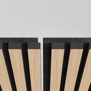 Close-up of Artikas Sonolok 15.5 ft sound-absorbing wall panel kit featuring wooden slats with a black backing, arranged diagonally with narrow vertical gaps, set against a plain light grey background.