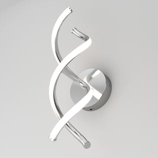 The Artika DNA modern LED wall sconce 3 CCT features two intertwined, curved metallic arms—one lit by integrated LEDs and the other reflective—mounted on a round silver base against a white wall.
