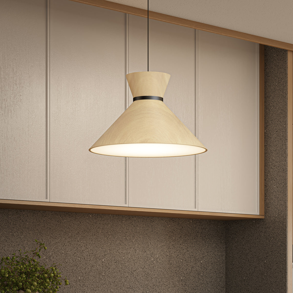 A modern pendant lamp with a light wood finish hangs from the ceiling in a kitchen with beige panel walls and a textured brown backsplash.
