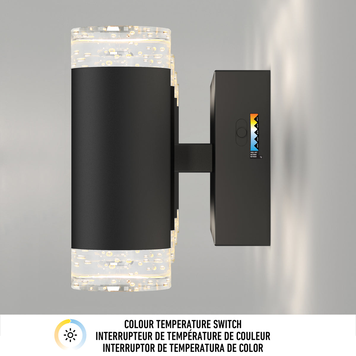 A modern black wall sconce with illuminated textured glass ends is mounted on a wall. A color temperature switch with five settings is visible on the side. Text below describes the color temperature switch in four languages.