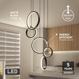 Modern kitchen with wood cabinets and a window with blinds features a matte black, circular LED pendant light. Text highlights adjustable height, energy efficiency, integrated LED, and a 5-year warranty.