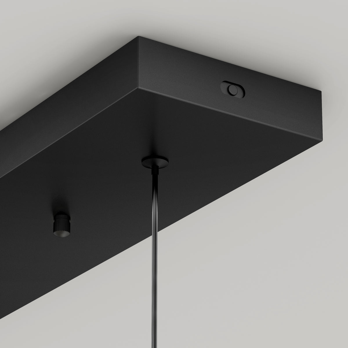 Close-up of the Artika Hanson 4-light LED pendant 5 CCT, a modern rectangular black fixture with adjustable color balance, hanging by a cord from a white ceiling.