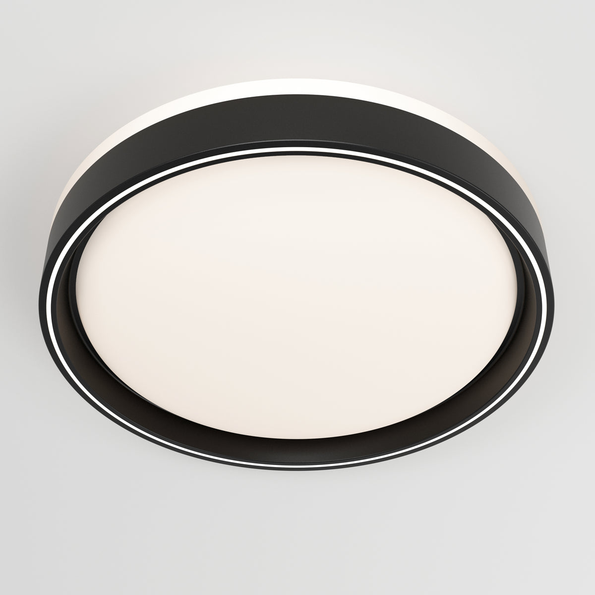 A modern, circular ceiling light with a black outer ring and a frosted white center, mounted on a plain white ceiling.