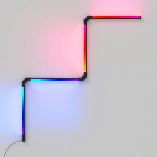 The Artika Fitch smart foldable RGB LED gaming floor lamp features four connected bars in a zigzag pattern, displaying gradients of red, pink, blue, and purple against a plain light-gray wall.