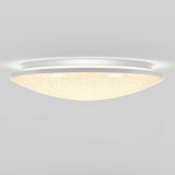 A modern, dome-shaped ceiling light fixture with a frosted, textured cover emits a soft, warm glow against a plain white ceiling.