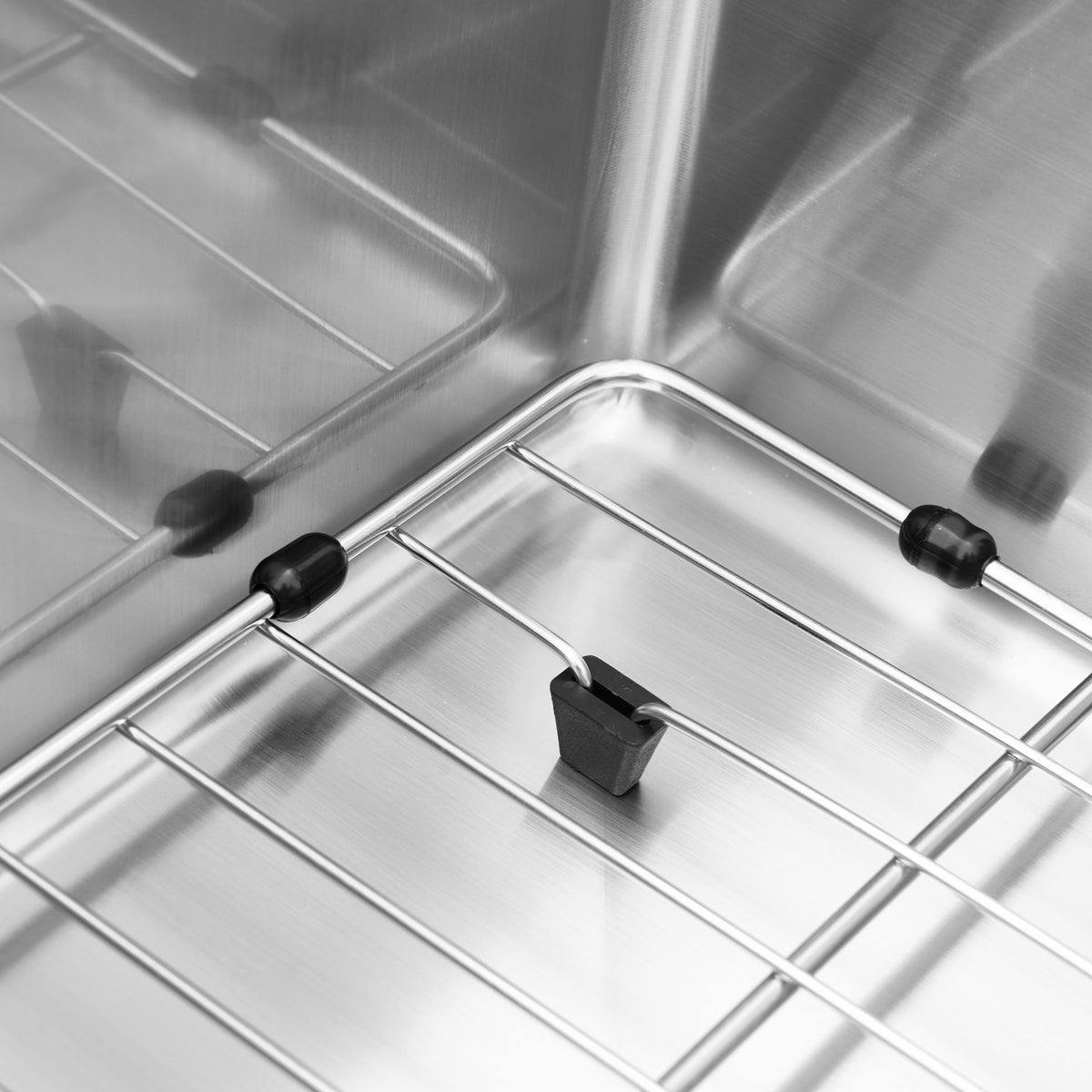 Close-up of the Neoflow single bowl 31 in. stainless steel workstation sink by Artika, showing metal wire racks and a small black temperature sensor attached to one rack, highlighting the premium sink’s detailed design.