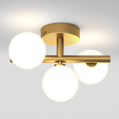 The Artika Bloom modern mid-century LED flush mount light 5 CCT features a gold finish with three asymmetrical frosted glass globes on a short bar, attached to a circular base, casting a soft ceiling glow.
