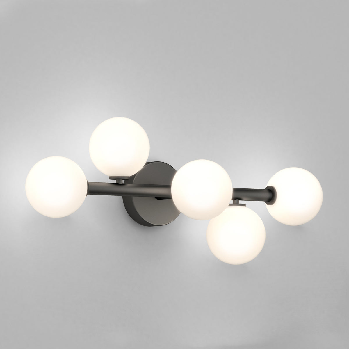 A modern wall sconce with five frosted glass globe bulbs arranged on a sleek, horizontal metal fixture against a plain light gray wall.