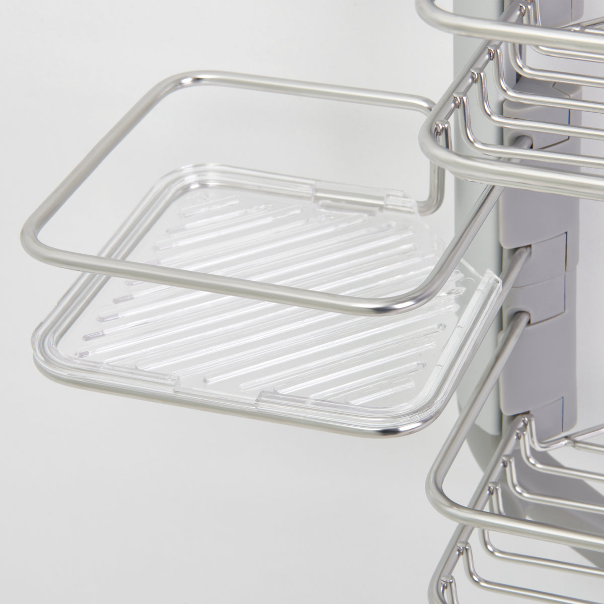 A close-up view of a metal and clear plastic wire shelf, attached to a vertical rail, designed for organizing items in a kitchen or bathroom cabinet.