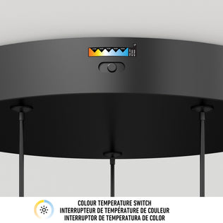 Close-up of the Elmo 5-light LED pendant by Artika, showing its black ceiling base and color temperature switch with a range of options. The label below reads COLOUR TEMPERATURE SWITCH in English and French.