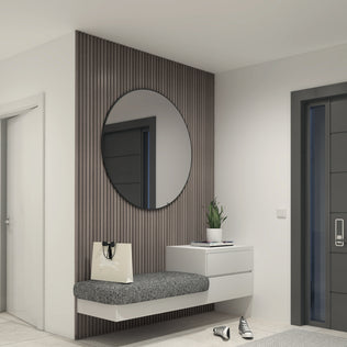 A modern entryway featuring a floating gray bench, round wall mirror, white drawer unit, potted plant, tote bag, sneakers on the floor, and white walls with a dark wood accent created by Artika’s Panolok 30.67 ft wall panel kit (pack of 8).