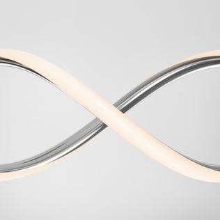The Artika DNA Linear LED modern pendant light features a sleek, curved infinity design with a silver metallic finish and emits a soft white glow, shown against a plain light gray background.