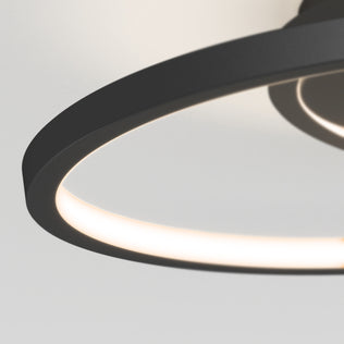 Close-up of the Artika Salto LED flush mount light, featuring a modern circular design with a sleek black frame and soft white illumination against a plain white ceiling.