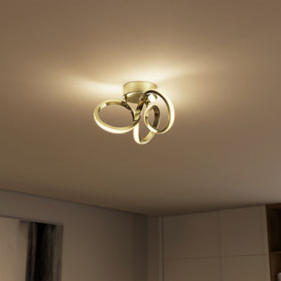 The Artika Swirl LED flush mount features gold loops and 1300 lumens, softly lighting beige rooms with modern style.