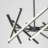 Modern chandelier with multiple intersecting, black metal arms, each featuring linear LED lights, suspended from a central rod against a plain white background.