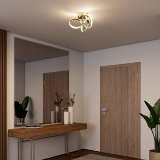Modern entryway with Artika's Swirl LED flush mount, wooden console table, large mirror, and potted plants.