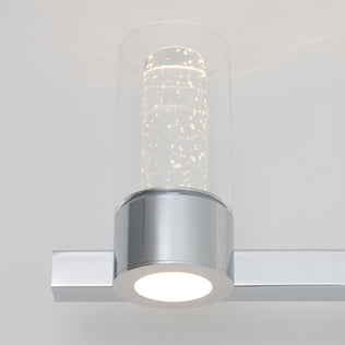 The Artika Novello LED vanity light features a modern chrome finish and a bubble-filled cylindrical glass shade.