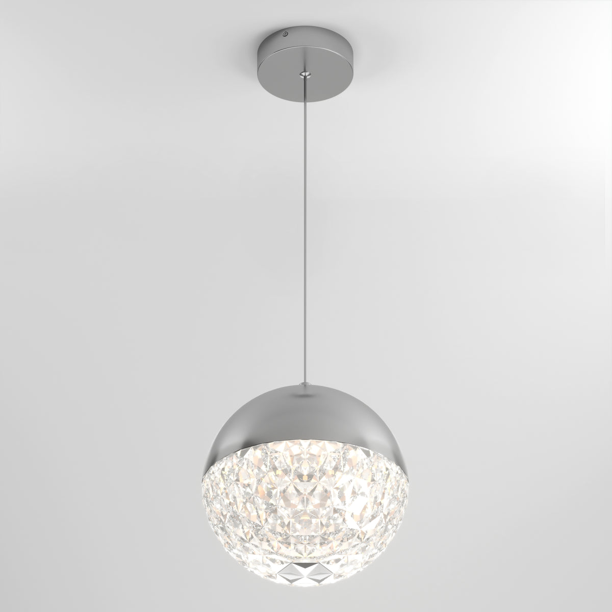A modern pendant light hangs from the ceiling, featuring a spherical design with a metallic top and a faceted, crystal-like lower half that diffuses light.