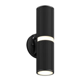A modern black cylindrical wall sconce with vertical grooves, mounted on a round base. The light emits from both the top and bottom, as well as a narrow band around the center.