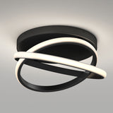 Modern ceiling light fixture with two interlocking oval rings, one emitting a soft white glow and the other a matte black band, mounted on a round black base against a light gray ceiling.