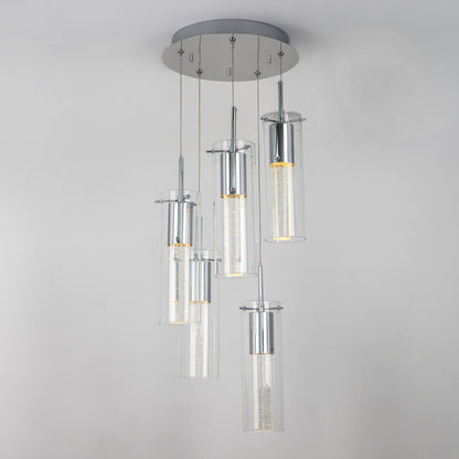 The Artika Essence 5-light LED pendant features five cylindrical glass fixtures at varying heights on a round chrome-accented base, showcasing visible LED filaments for a modern look.