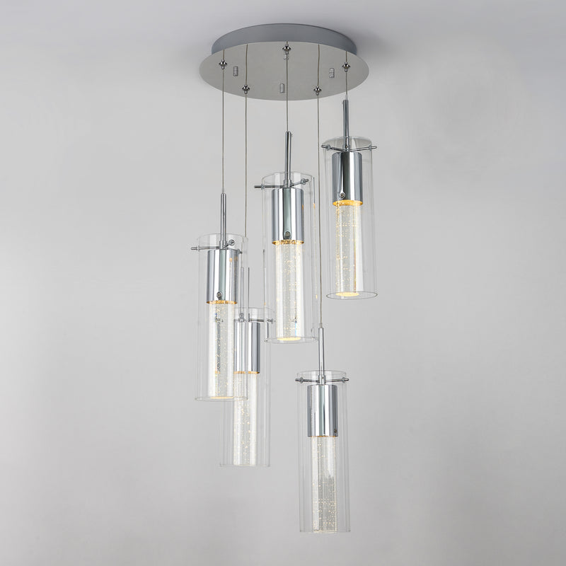 The Artika Essence 5-light LED pendant features five cylindrical glass fixtures at varying heights on a round chrome-accented base, showcasing visible LED filaments for a modern look.