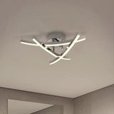 Modern ceiling light fixture with three curved, intersecting LED bars attached to a round chrome base, mounted on a smooth white ceiling in a minimalist room with neutral-colored walls.