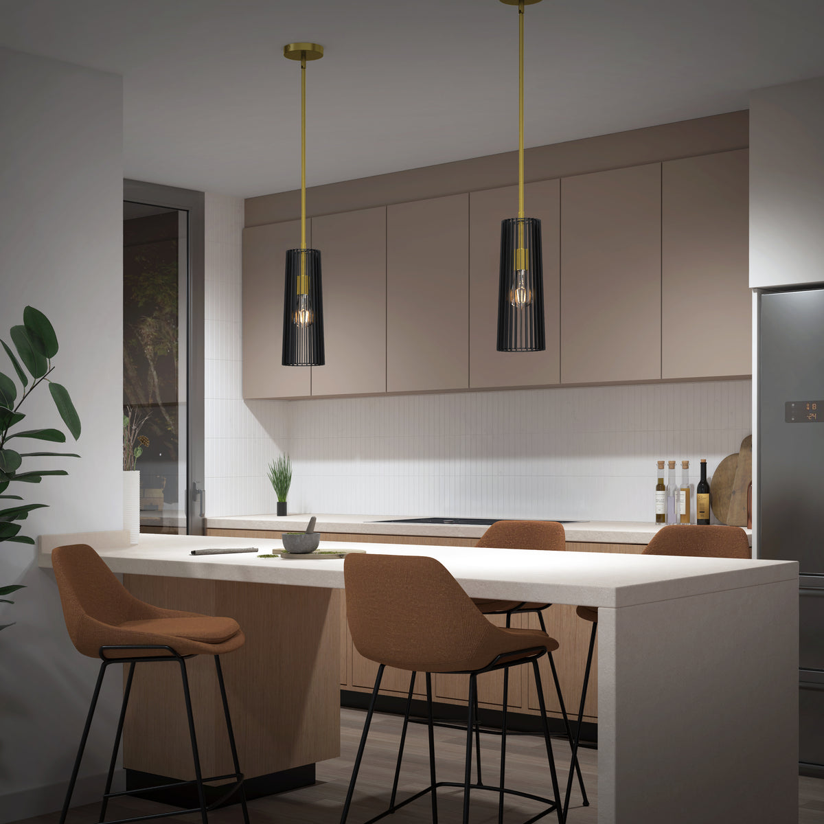 Modern kitchen featuring beige cabinets, a white island with four brown bar stools, two Artika Gatsby Mini modern mid-century pendant lights, a corner plant, stainless steel refrigerator, window, and kitchen accessories in the background.