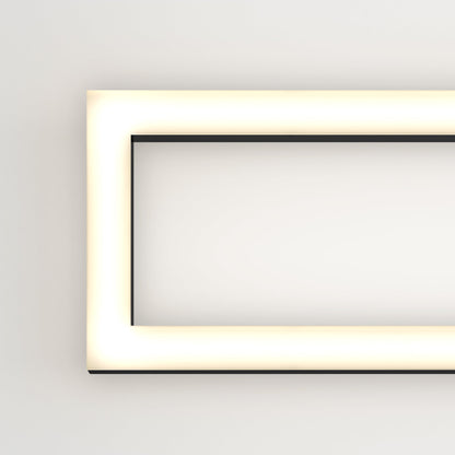 The Artika-CAN-dev Dover modern LED bathroom vanity light 5 CCT glows warmly on a white wall, with its illuminated frame visible along the left and top edges.