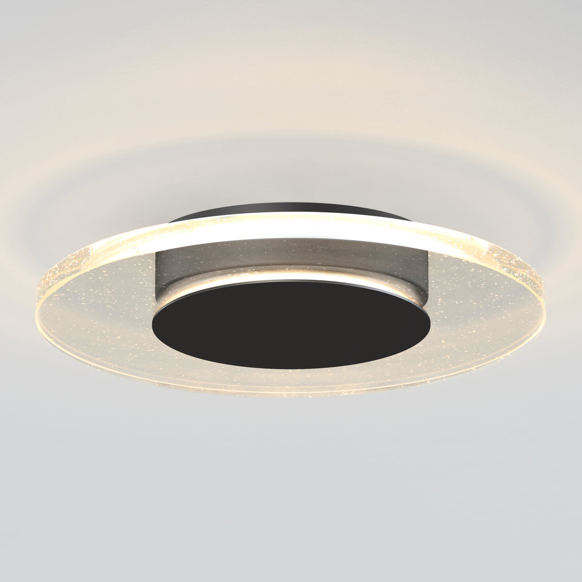 A modern, circular ceiling light fixture with a black center and a translucent outer ring that emits a soft, even glow, mounted on a white ceiling.