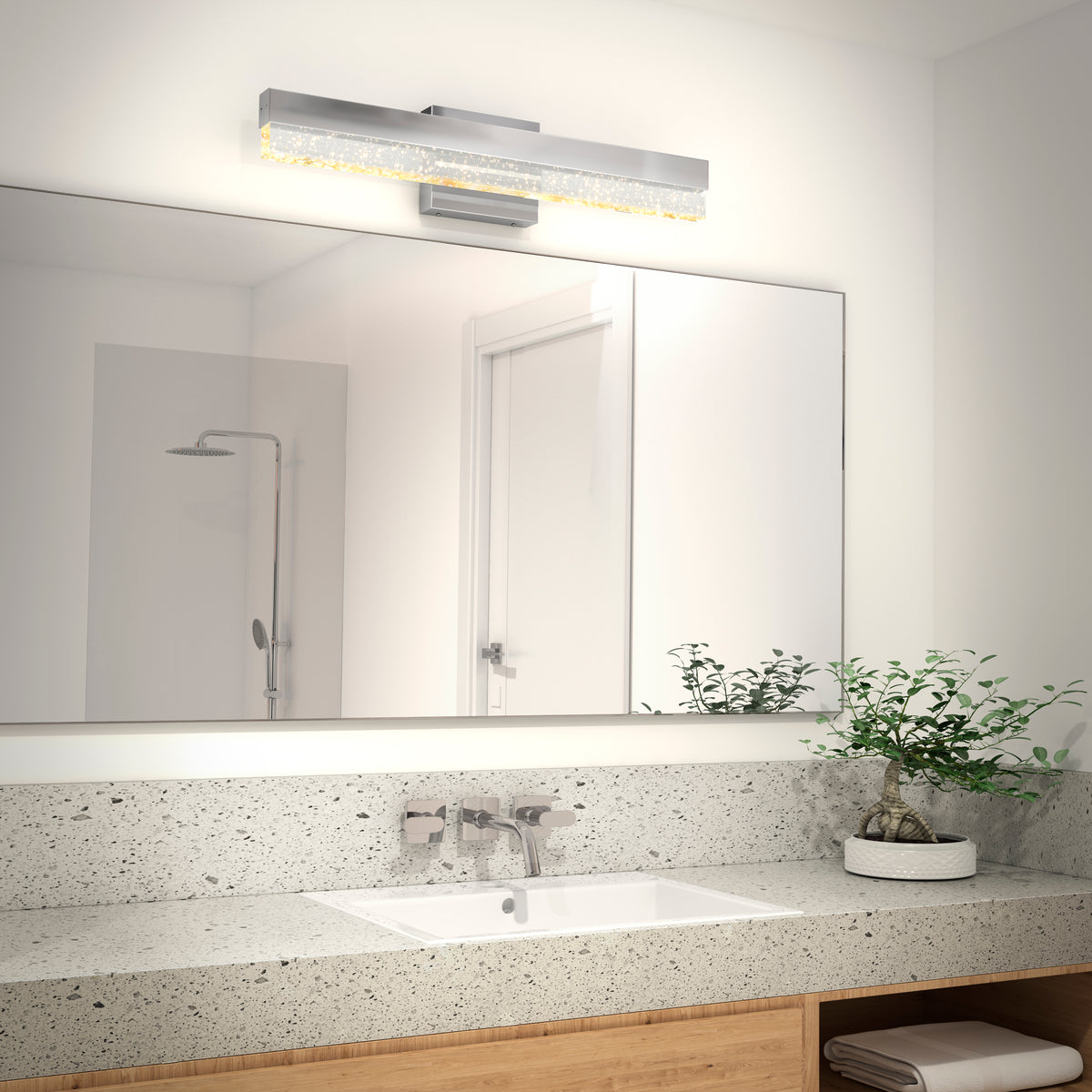 Modern bathroom with a large mirror, modern counter, rectangular sink, potted plant, and Artika Essence Bubble Bar LED vanity light above.