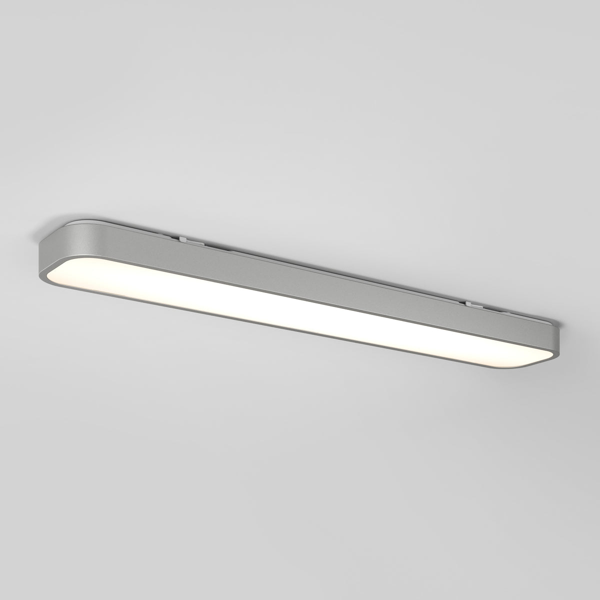 A modern, rectangular LED ceiling light fixture with a sleek silver frame is mounted on a white ceiling, emitting a bright, even glow.