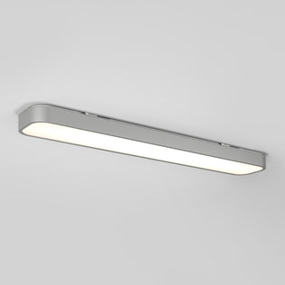 The Artika Europa 36 LED flush mount light, featuring a slim silver frame and white diffuser, is mounted on a light gray ceiling and illuminated, casting a soft glow. This modern fixture includes a remote for convenient control.