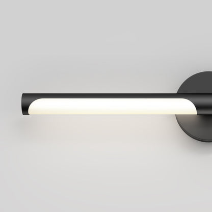The Artika Ilona LED bathroom vanity light 5 CCT features a modern, minimalist black cylindrical design with a glowing white light, mounted on a round black wall plate against a plain light gray background.